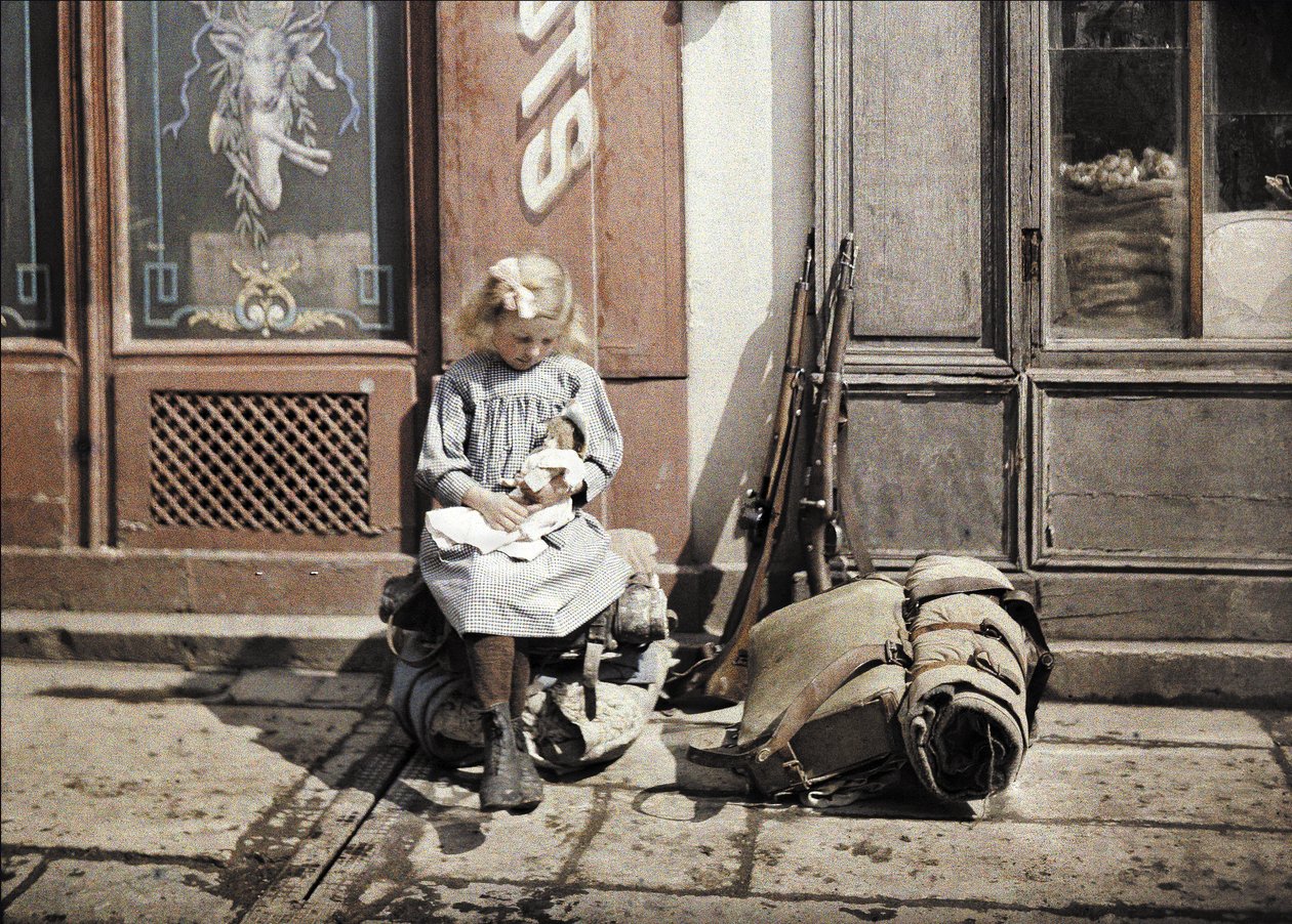 A Little Girl Playing with Her Doll; Two Guns and a Knapsack are Next to Her on the Ground, Reims, Marne, France, 1917 by Fernand Cuville