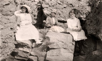 Three Women Relaxing on Rocks by Unbekannt