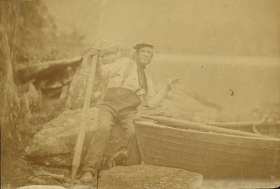 Man Posing Beside Rowboat by Unknown artist/maker
