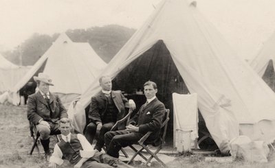 Men relaxing outside their tent by . .